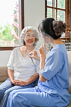Young Asian female doctor using a stethoscope to listen to a patient`s heartbeat, diagnose