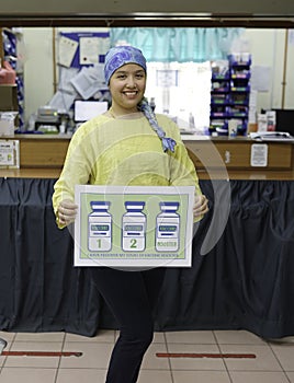A young asian female frontliner holding a sign showing that she had taken her booster dose of Covid-19 vaccine.