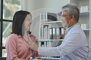 A young Asian female patient is being examined by a medical professional, A dignified middle-aged male doctor is diagnosing a