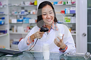 Young asian female pharmacist are scanning barcodes on white medicine bottles
