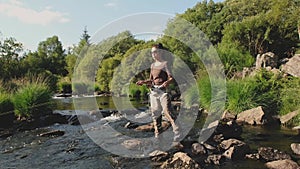 A young asian female standing fly fishing in a riffle on a river