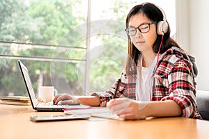 Young Asian female student working and studying from home