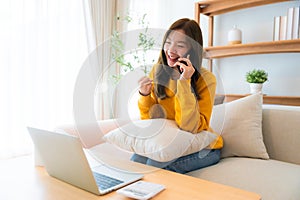 Young Asian female wearing glasses using laptop