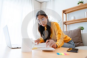 Young Asian female wearing glasses using laptop
