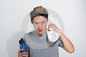 Young Asian fitness man holding towel and bottle with water isolated on a white background