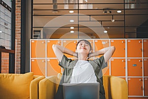 Young Asian freelancers are stretching oneself and relaxing after working and planning to work while working on laptop in the cafe photo