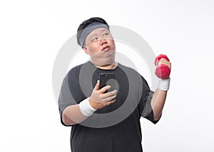 Young Asian funny fat sport man exercise with dumbbell and using smartphone isolated on white background.