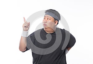 Young Asian funny fat sport man pointing to copy space isolated on white background.