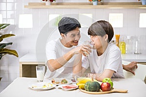 young Asian gay man feed milk to his lgbtq partner on breakfast