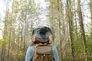 Young Asian girl with a backpack and hat hiking in the mountains during the summer season