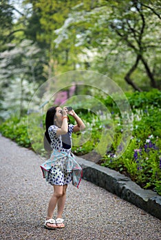 Young asian girl birdwatching with binocular in the nature