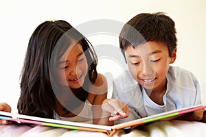 Young Asian girl and boy reading book