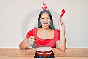 Young asian girl celebrating birthday with cake celebrating crazy and amazed for success with open eyes screaming excited