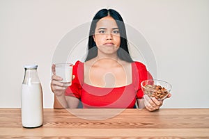 Young asian girl drinking healthy almond milk depressed and worry for distress, crying angry and afraid