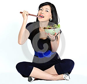 Young asian girl eating salad