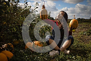 Young asian girl farmer at the autumn pumpkin patch background. Having fun and posing.