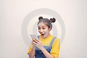 Young Asian girl hodling phone and surprised