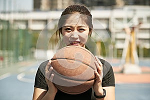 Young asian girl holding a basketball