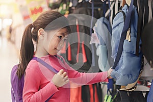 Young asian girl kid or cute pupil buying school satchel or bag in store, Selective focus