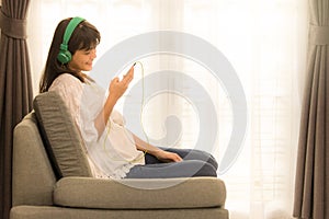 Young Asian girl listening to music with headphone and smarthphone