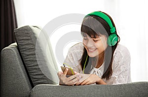 Young Asian girl listening to music with headphone and smarthphone
