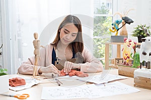 Young Asian girl making a sculpture with modeling clay at home .hobby clay sculpt concept.