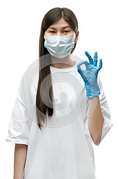 Young asian girl in medical mask and blue gloves show ok sign