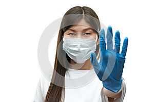 Young asian girl in medical mask and blue gloves show stop sign