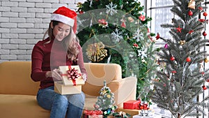 Young Asian girl opening gift box with happy face in Christmas morning