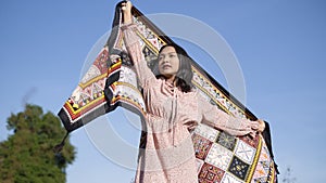 Young asian girl standinf at field grass and blue sky