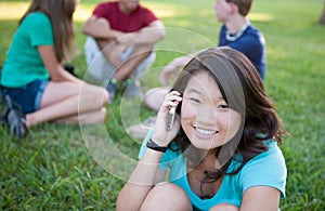 Young Asian girl talking on phone outside