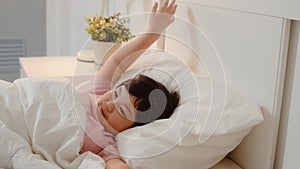 Young Asian girl wake up at home. Asia japanese woman child kid relax rest after sleep all night lying on bed, feel comfort and