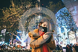 Young asian girl wearing a mouth mask with smart phone.