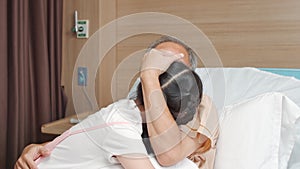 Young Asian granddaughter visit and hug sick grandfather on hospital bed in hospital private senior patient room
