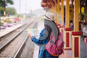 Young asian gril walking at train station before travel. work and travel concept photo