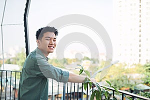 Young asian guy waiting and leaning in hand rail