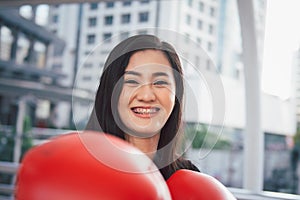 Young Asian healthy life woman with red boxing punching gloves, smiling face