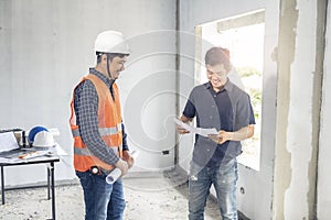Young asian inspector checking house with foreman engineering home inspection building house Walk home inspection with looking and