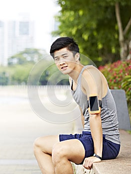 Young asian jogger taking a break