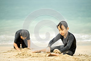 Young asian kids are playing on the beach.