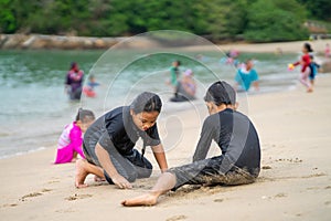 Young asian kids are playing on the beach. Vacation and relax concept