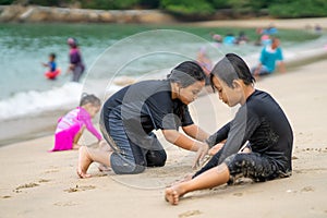 Young asian kids are playing on the beach. Vacation and relax concept