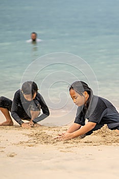 Young asian kids are playing on the beach. Vacation and relax concept