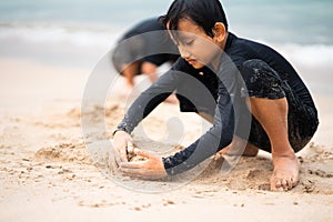 Young asian kids are playing on the beach. Vacation and relax concept