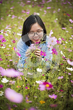 Young Asian lady smiling holding flowers at meadows