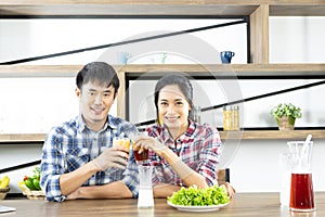 Young Asian lovely couple drinking coffee with milk in kitchen at home, married people lifestyle