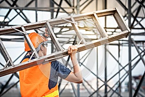 Young Asian maintenance worker carrying aluminium ladder