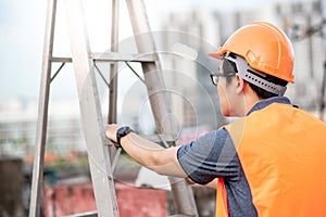 Young Asian maintenance worker carrying aluminium ladder