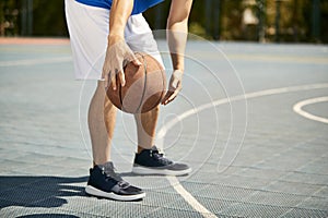 Young asian male basketball player practicing dribbling