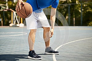 Young asian male basketball player practicing dribbling